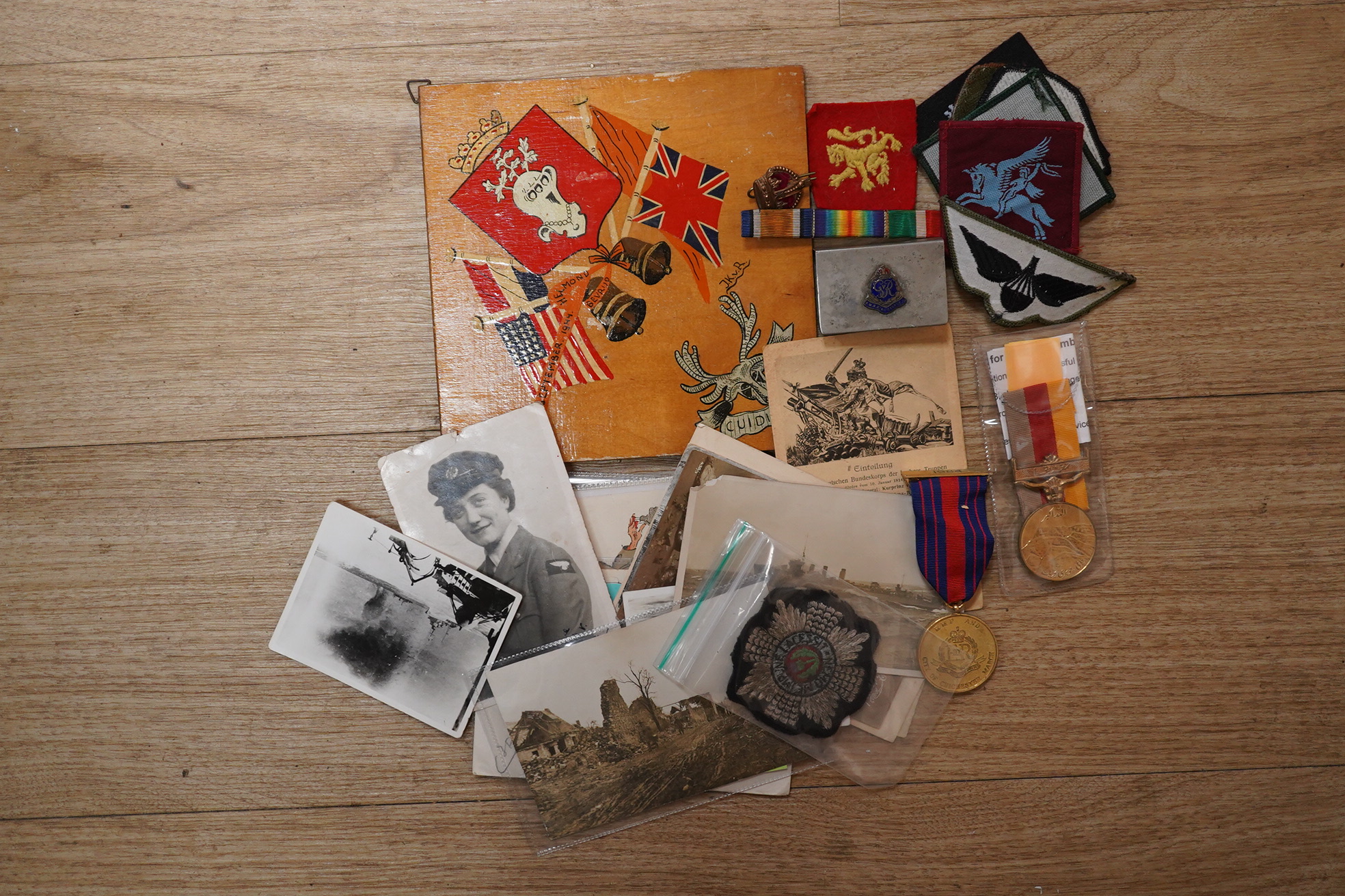 A quantity of various military ephemera to include a Coldstream guards matchbox holder, a death plaque and another 19th century glass plaque, buttons, badges, National Registration Identity Card, various photos and lette